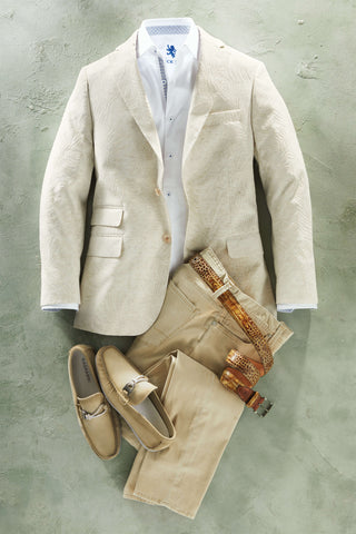 Beige suit with white shirt, loafers, and belt on a gray concrete surface