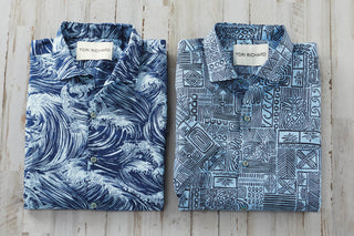 Two patterned shirts by Tom Richard on a wooden surface