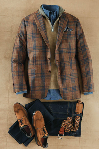 Plaid jacket, jeans, brown shoes, and accessories on a beige background