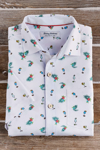 Folded white shirt with colorful pattern on a wooden surface