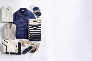 Collection of men's clothing including shirts, pants, and shoes on a light gray background