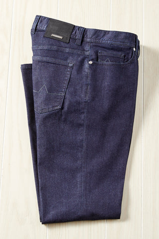 Pair of dark blue jeans on a light wooden surface