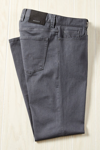 Folded gray jeans on a light wooden surface